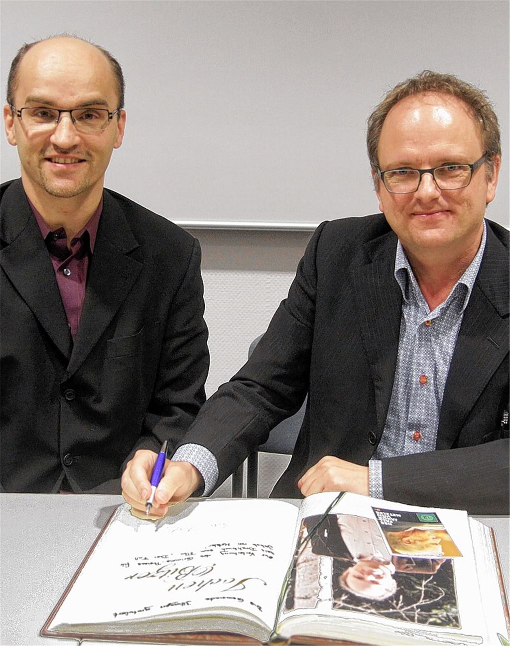 Bürgermeister Harald Eiberger freut sich, dass sich jetzt auch der renommierte Drehbuchautor Jochen Bitzer in das Goldene Buch seiner Heimatgemeinde Illingen einträgt. Foto: Goertz