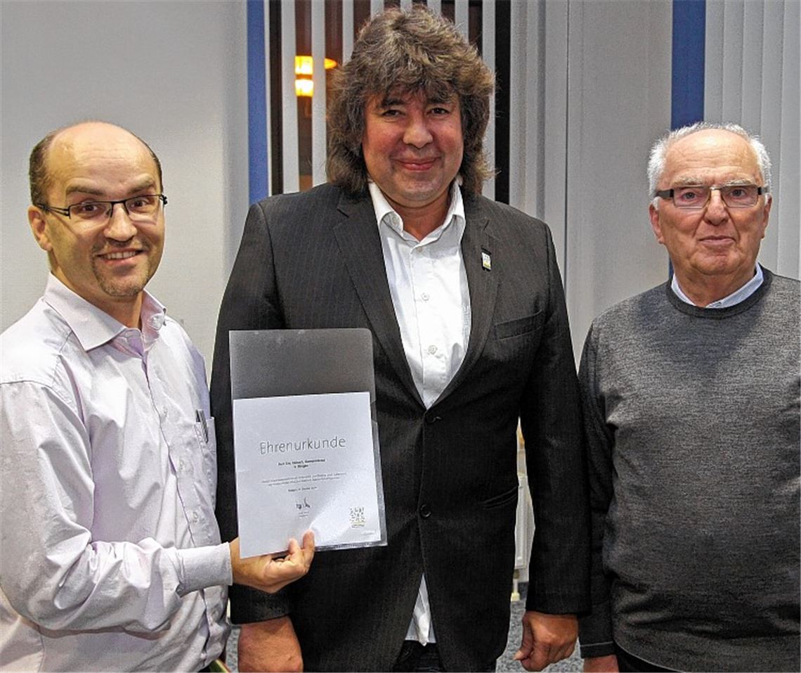 Bürgermeister Harald Eiberger (li.) und sein ehrenamtlicher Stellvertreter Winfried Scheuermann (re.) ehren Eric Schach für sein 20-jähriges Engagement als Gemeinderat. Foto: Goertz