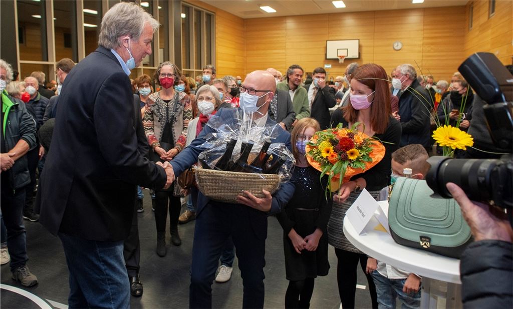 Bürgermeister Heinz-Peter Hopp (li.) gratuliert seinem Nachfolger Alexander Kozel. Bilder rechts von oben nach unten: Zunächst müssen Kozel, Ehefrau Sonja und die Kinder noch warten. Rasch ist klar, dass es für Florian Blume (v.li.), Andreas Laitenberger und Jochen Stöhr nicht gereicht hat. Platz drei erreicht Klaus Meiser (unten li.). Fotos: Fotomoment