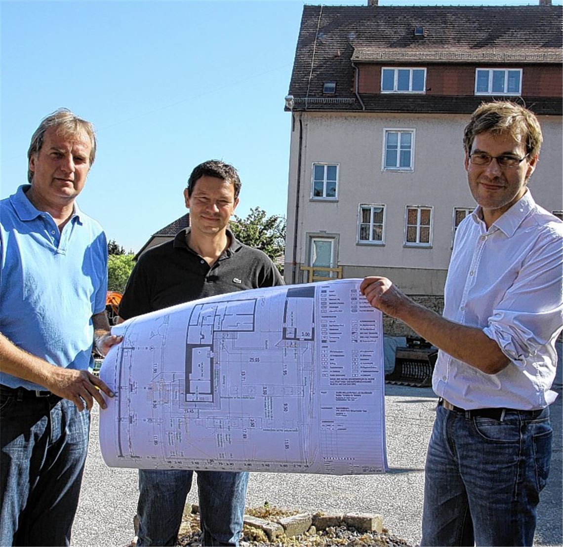 Bürgermeister Heinz-Peter Hopp (v.li.) und die beiden Architekten Patric Göhner und Gunther Schrade mit einem Plan der Tiefgarage in Knittlingen. Bild rechts: ein Meißelbagger im Einsatz.