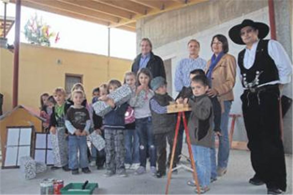 Bürgermeister Hopp, Architekt Entenmann, Kindergartenleiterin Rohde und Zimmermeister Dürr (v. li.) feiern mit den Kindern Richtfest. Foto: Hansen