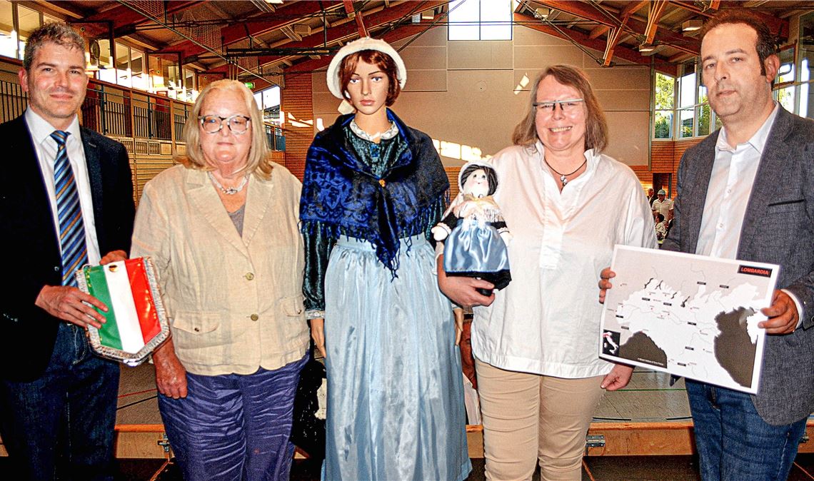 Bürgermeister Matthias Enz, Marisa Maccari, Heidrun Wolfmüller und Bürgermeister Roberto Rostagno (v. li.) mit dem Gastgeschenk – einer Puppe, die eine Waldensertracht trägt. Foto: Stahlfeld