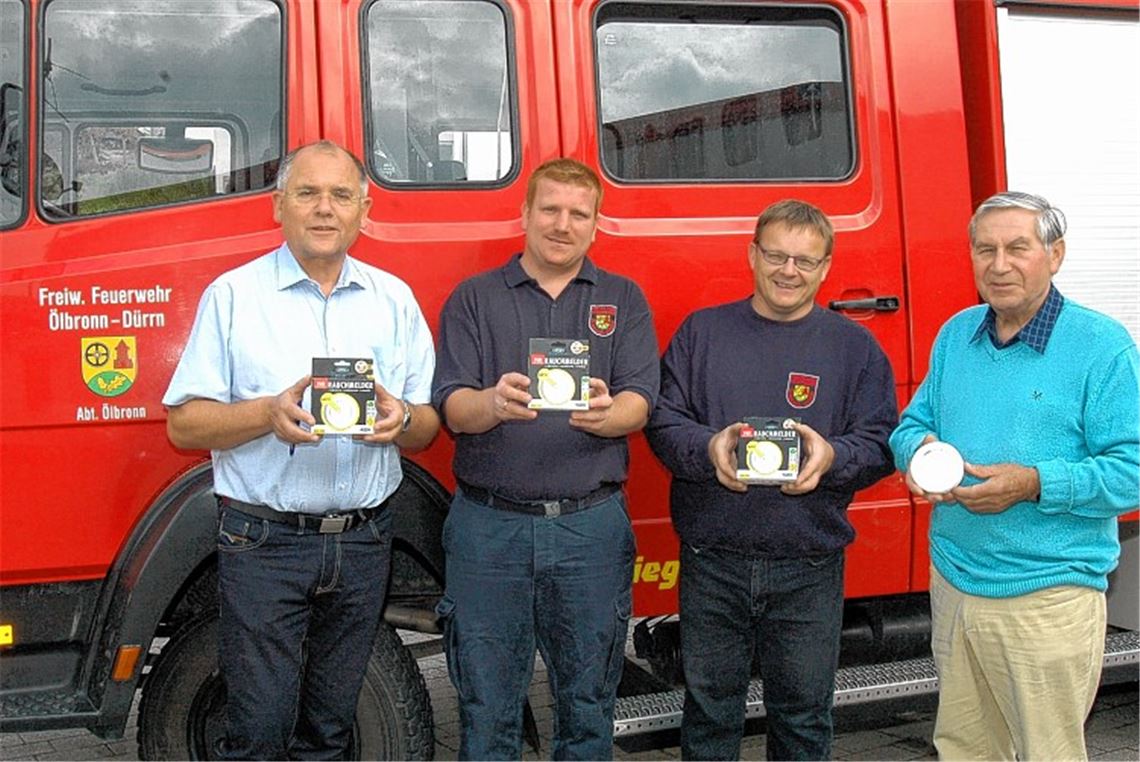 Bürgermeister Norbert Holme, Vizekommandant Ronny Lieb, von dem die Idee zur Aktion stammte, Kommandant Jürgen Braun und Brandschutzexperte Klaus Reinacher präsentieren vier der lebensrettenden kleinen Geräte. Foto: Schott
