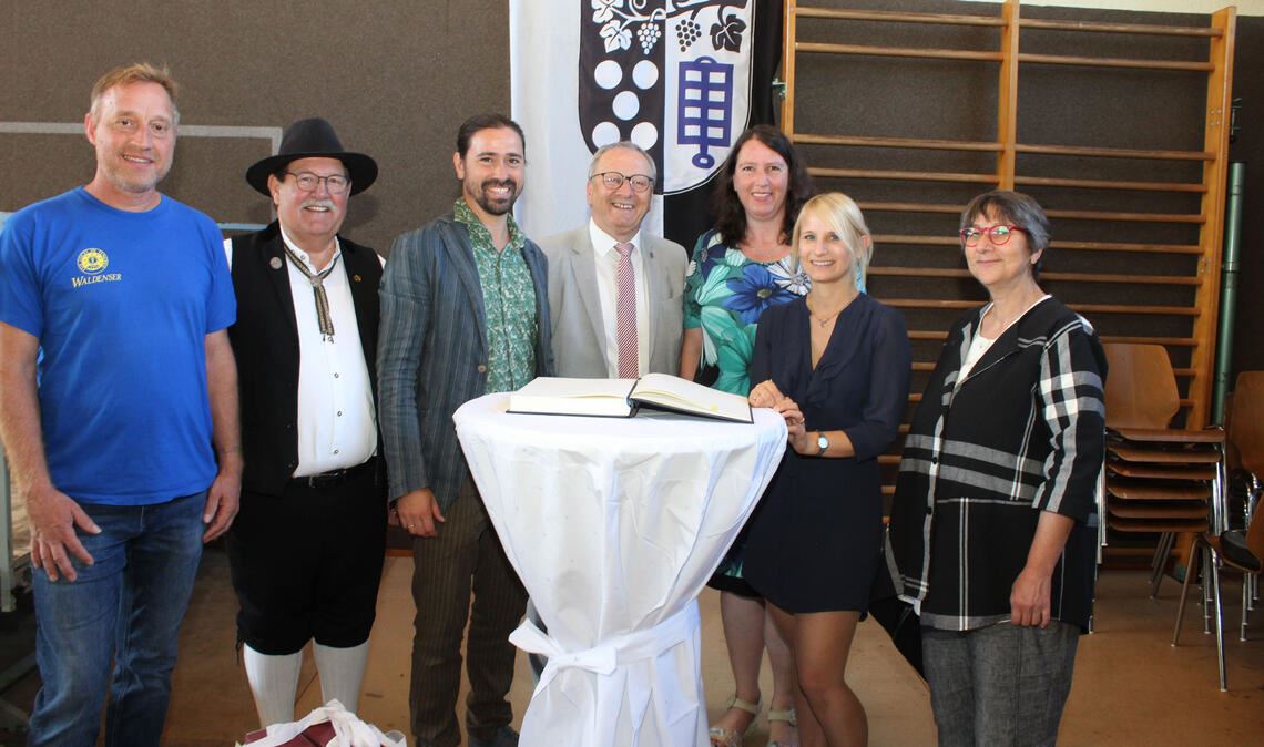 Bürgermeister Thomas Nowitzki (Mitte) lässt in Großvillars die Akteure des Deutschen Waldensertages Stefan Mondon (v.li.), Oskar Combe, Lukas Frei, Karina Beck, Daniela Falz sowie Hiltrud Stahlberger-Vogel ins goldene Buch der Stadt Oberderdingen schreiben. Foto: Prokoph
