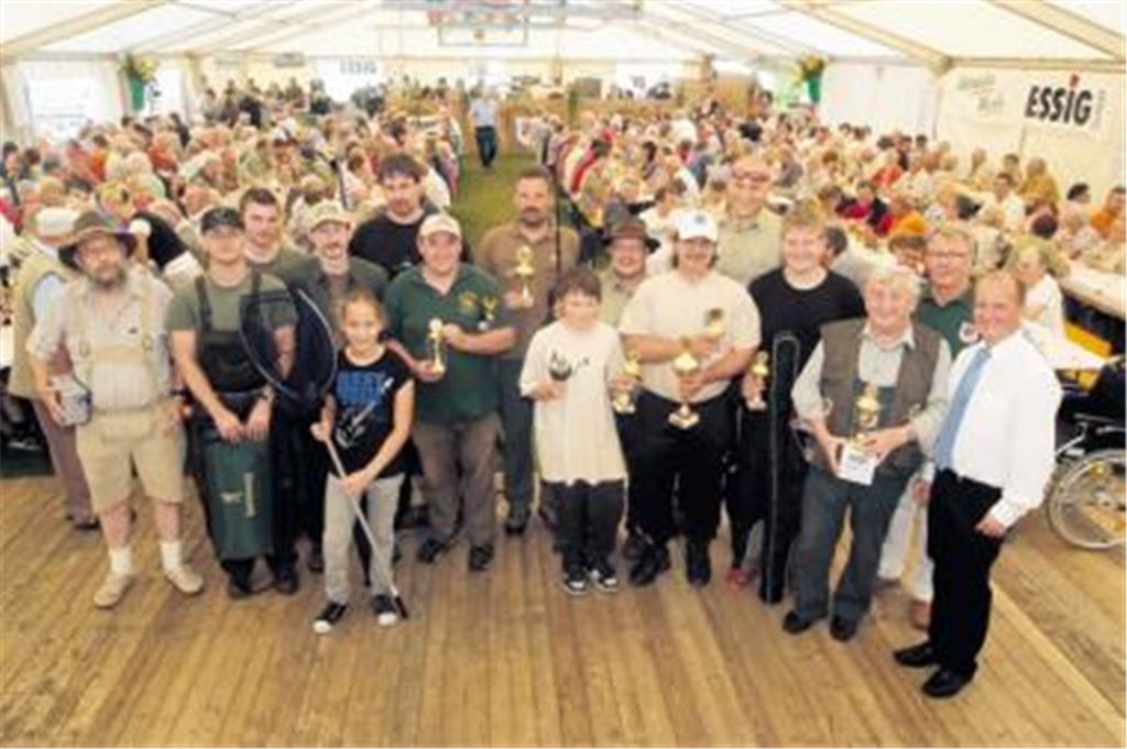 Bürgermeister Winfried Abicht und der Ehrenvorsitzende des Sportfischereivereins Mühlhausen/Enz, Wolfgang Schreiber, (v. re.) überreichten die Pokale und Sachpreise. Foto: Fotomoment 