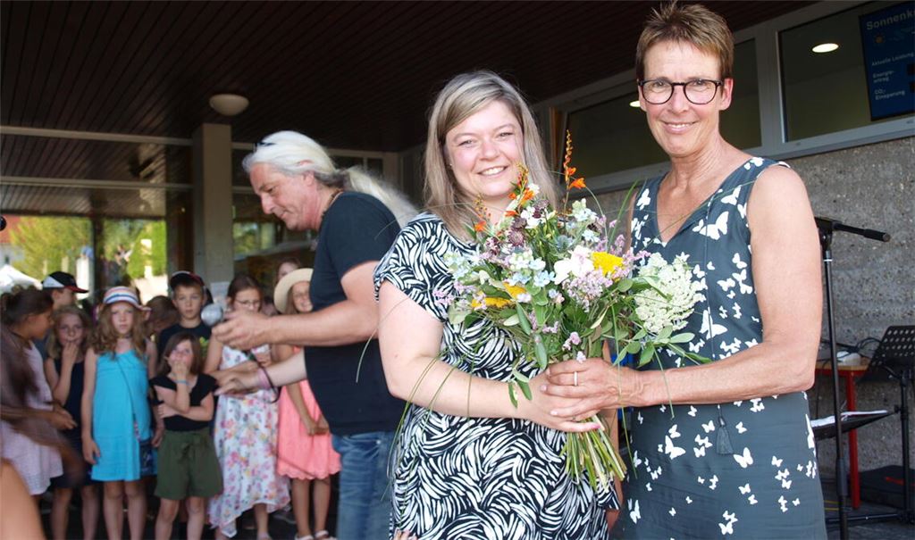 Bürgermeisterin Antonia Walch dankt der scheidenden Schulleiterin Susanne Sieber-Böhler (re.). Im Hintergrund bereitet sich der Schulchor vor. Foto: Filitz