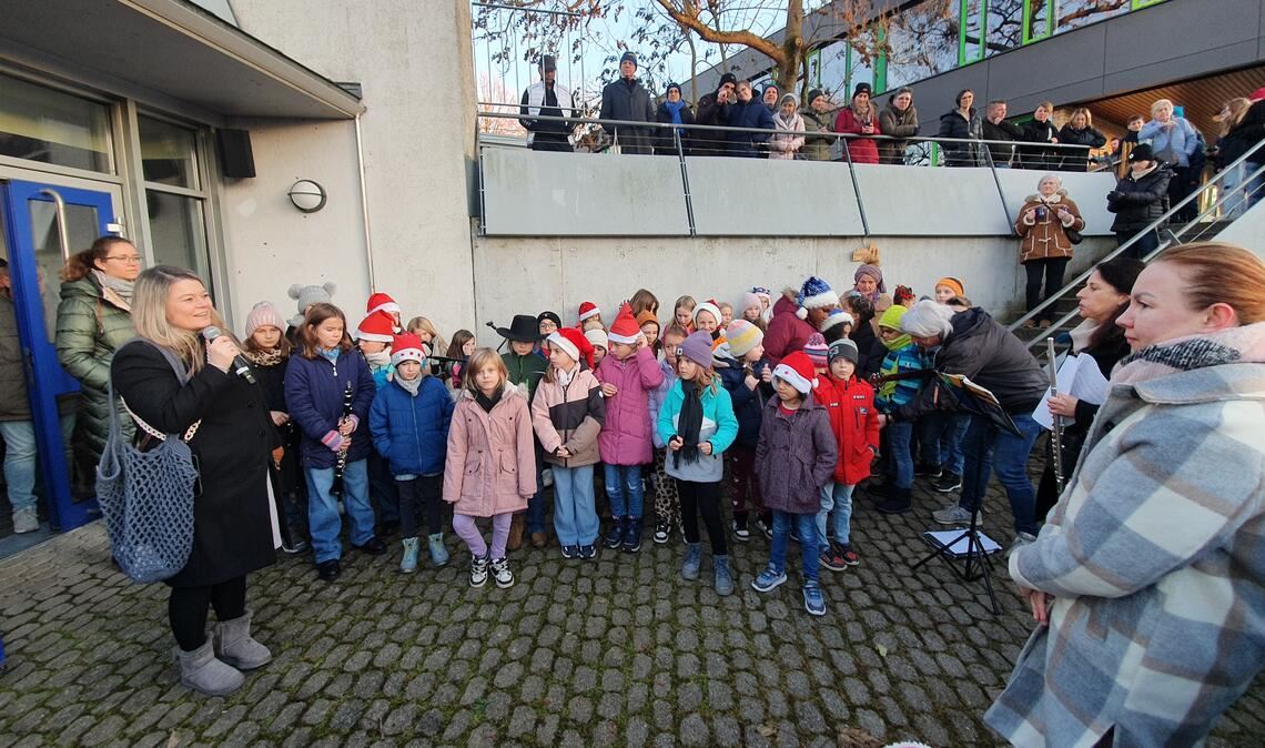 Bürgermeisterin Antonia Walch, die Mitte März ihr zweites Kind erwartet, eröffnet den Weihnachtsmarkt unter den Klängen des Grundschul-Chors und der Musik-AG. Fotos: Schröder