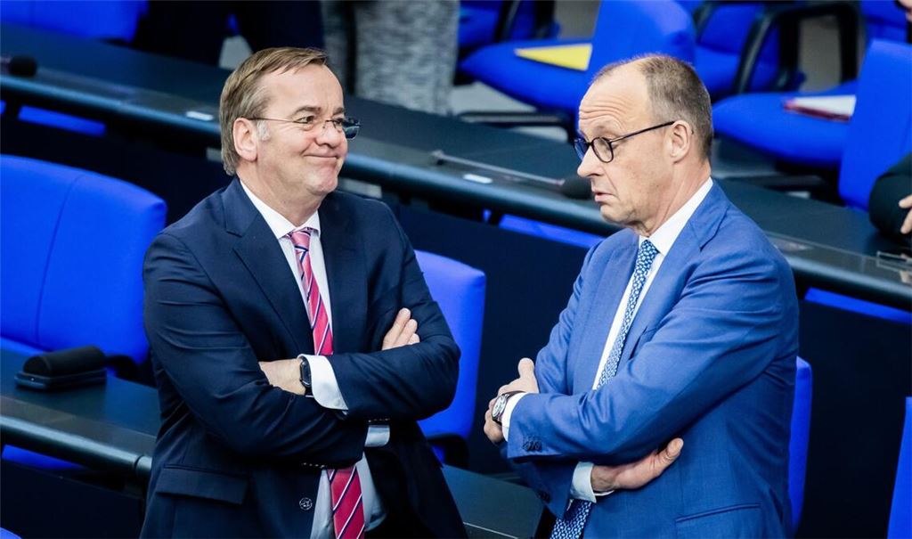 Bundeskanzler Friedrich Merz (CDU, r) und Boris Pistorius (SPD), Bundesminister der Verteidigung, unterhalten sich im Plenum des Deutschen Bundestages.