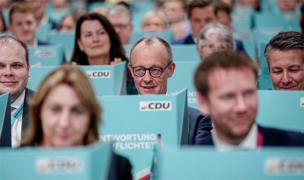 Bundeskanzler Friedrich Merz (M), CDU-Parteivorsitzender, sitzt hinter seiner Wahlkabine.
