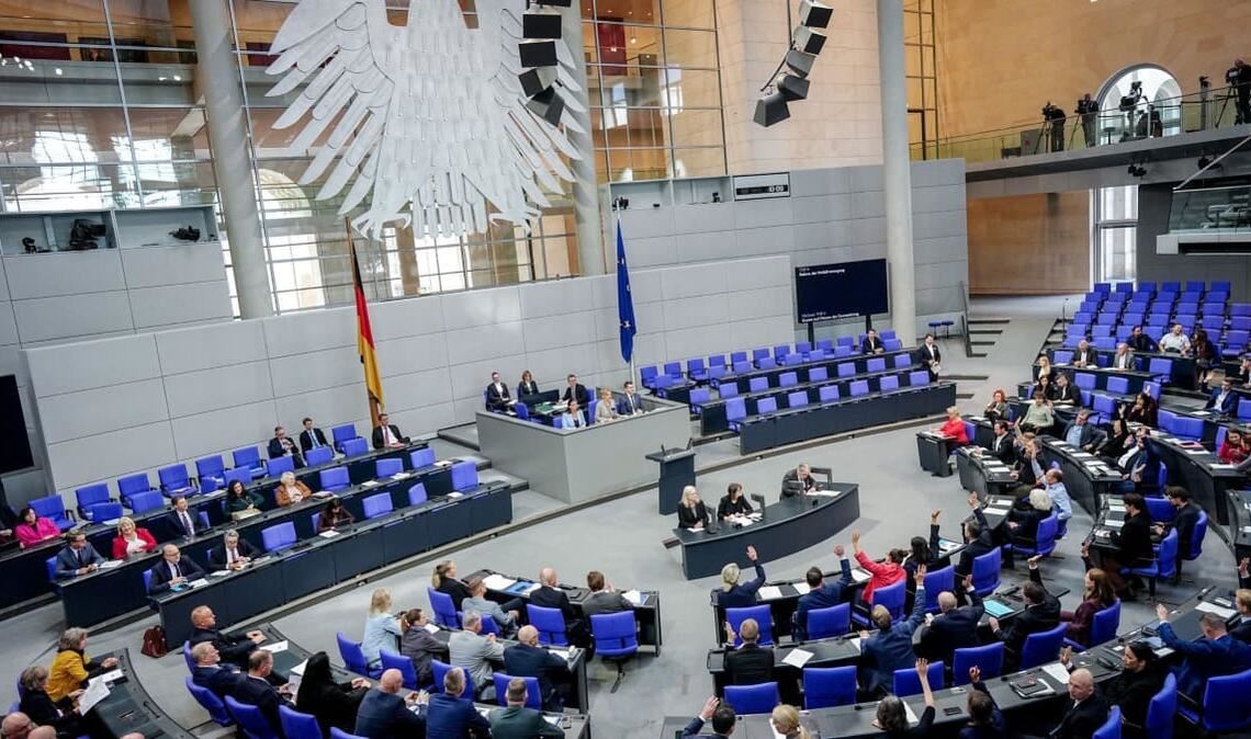 Bundestagsabgeordnete heben die Hand für eine Abstimmung bei der Sitzung des Bundestags.