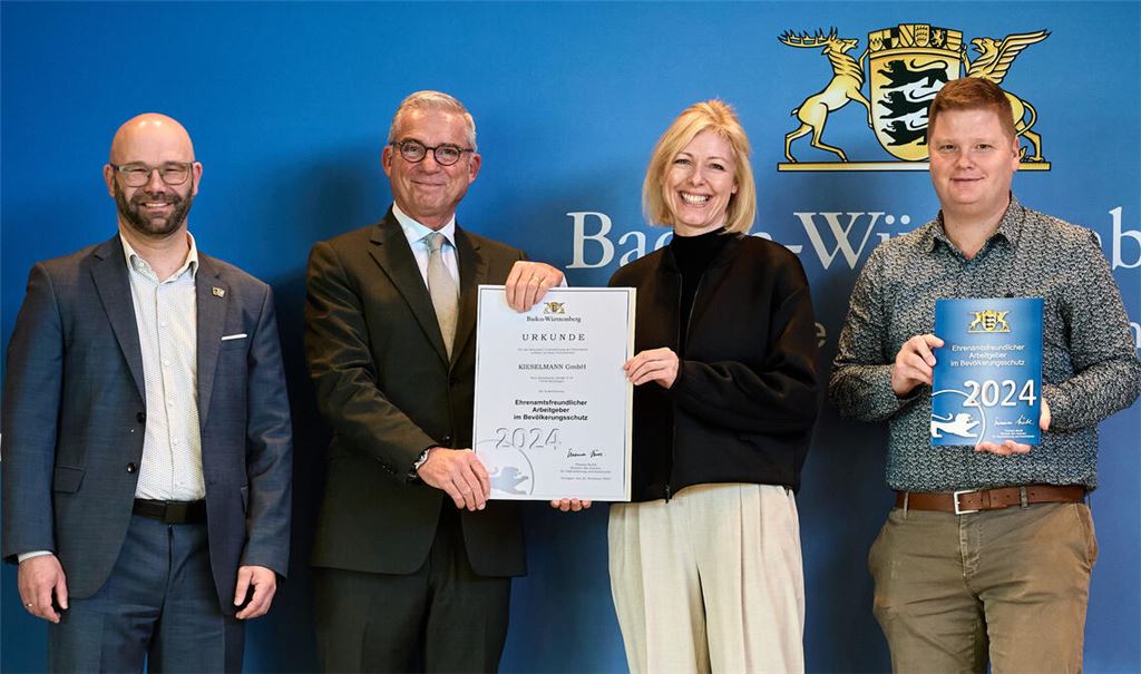 Caroline Pötzl, Geschäftsführerin bei Kieselmann, nimmt zusammen mit Mitarbeiter und Feuerwehrmann Fabian Gerst (re.) die Urkunde von Innenminister Thomas Strobl entgegen. Die Auszeichnung als ehrenamtsfreundlichen Arbeitgeber angeregt hatte Knittlingens Bürgermeister Alexander Kozel (li.). Foto: Innenministerium