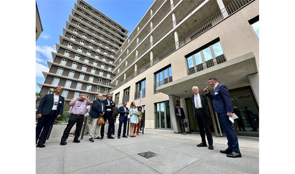 Carsten von Zepelin (re.) begrüßt Ministerpräsident Winfried Kretschmann (2.v.re.) im Innenhof des Gebäudekomplexes, bestehend aus dem Holz-Hybridhochhaus CARL und dem angrenzenden fünfgeschossigen Baukörper. Foto: Staatsministerium