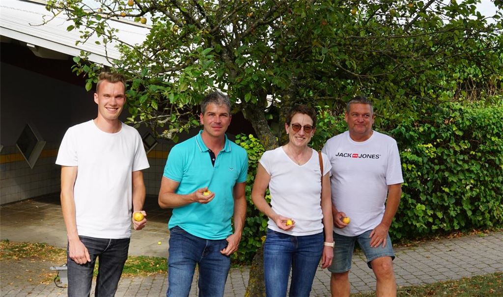 Cedric Wolfmüller (v.li.), Student und Fachwart Obstbau beim Landratsamt, Bürgermeister Matthias Enz, Anja Sadler-Glos und Harald Pflüger von der „Liste LAND“ stehen vor einem gemeindeeigenen Apfelbäumchen der Sorte Goldparmäne. Foto: Bastian