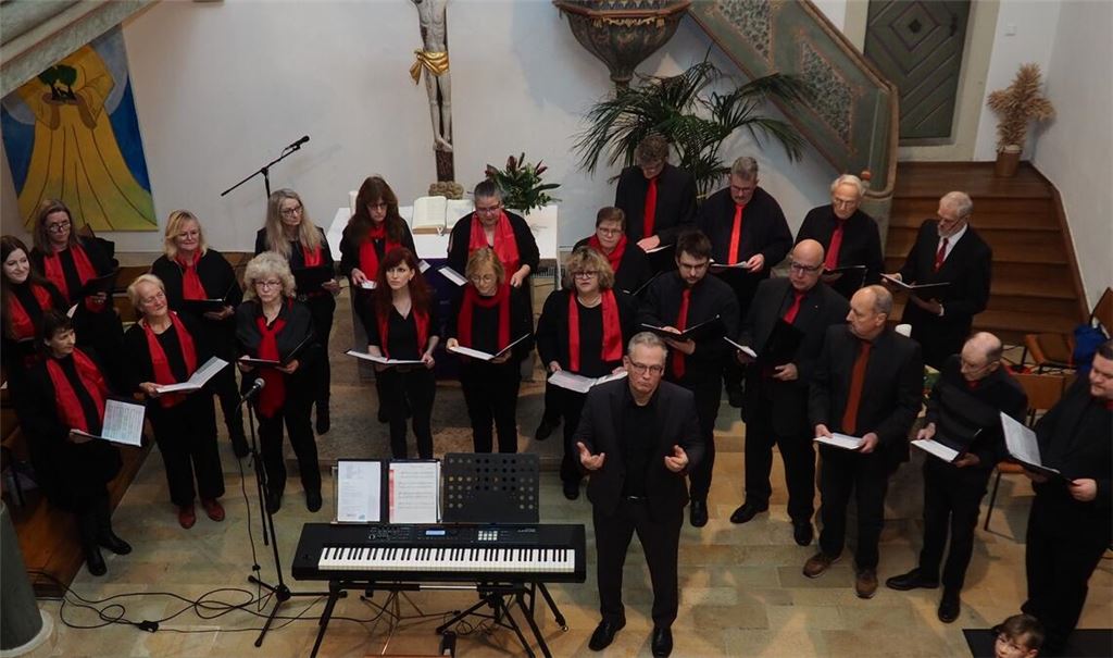 Chorleiter Ralf Schwarzien (rechts neben dem E-Piano) vermittelt Informationen zum Inhalt der Liedtexte. Foto: Müller