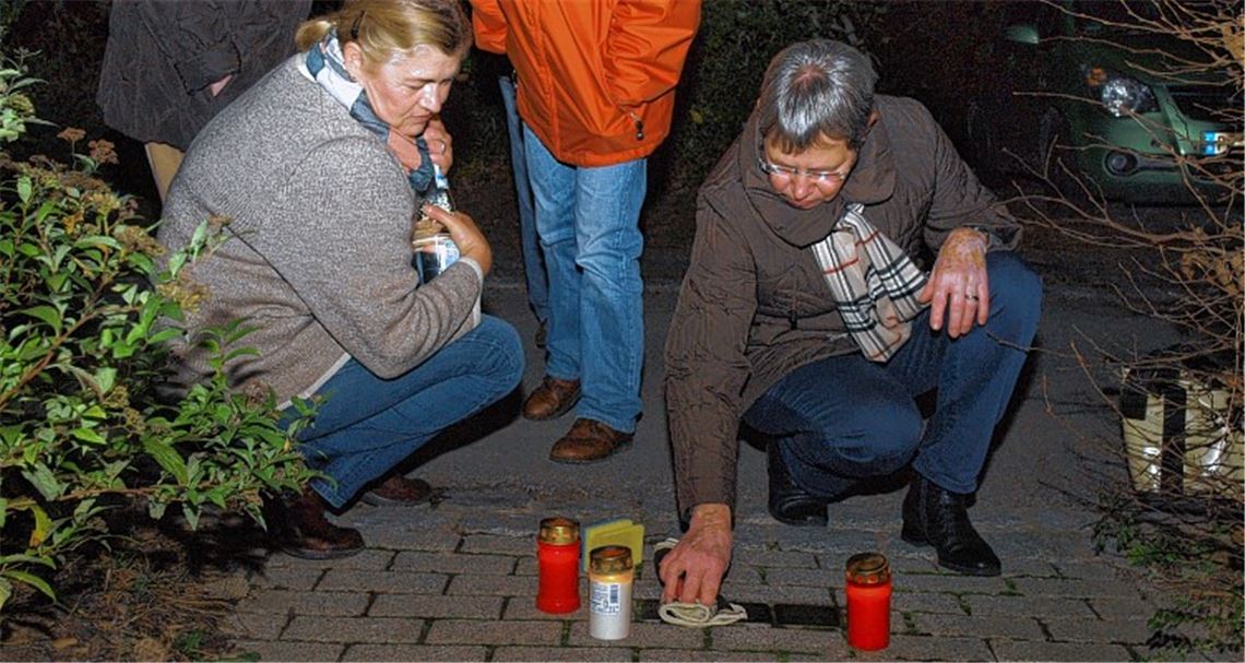 Christiane Bastian-Engelbert putzt die Stolpersteine vor der Villa Emrich. Foto: Appich