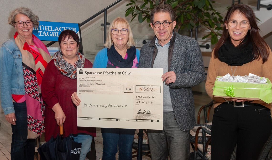 Claudia Schäfer (li.) und Tanja Keller (re.) freuen sich mit Verleger Hans-Ulrich Wetzel über den Betrag, der bei der Glücksrad-Aktion zusammengekommen ist und den – per symbolischem Scheck – Karin Lutz (ab 2.v.li.) und Carmen Olt entgegennehmen. Foto: Fotomoment