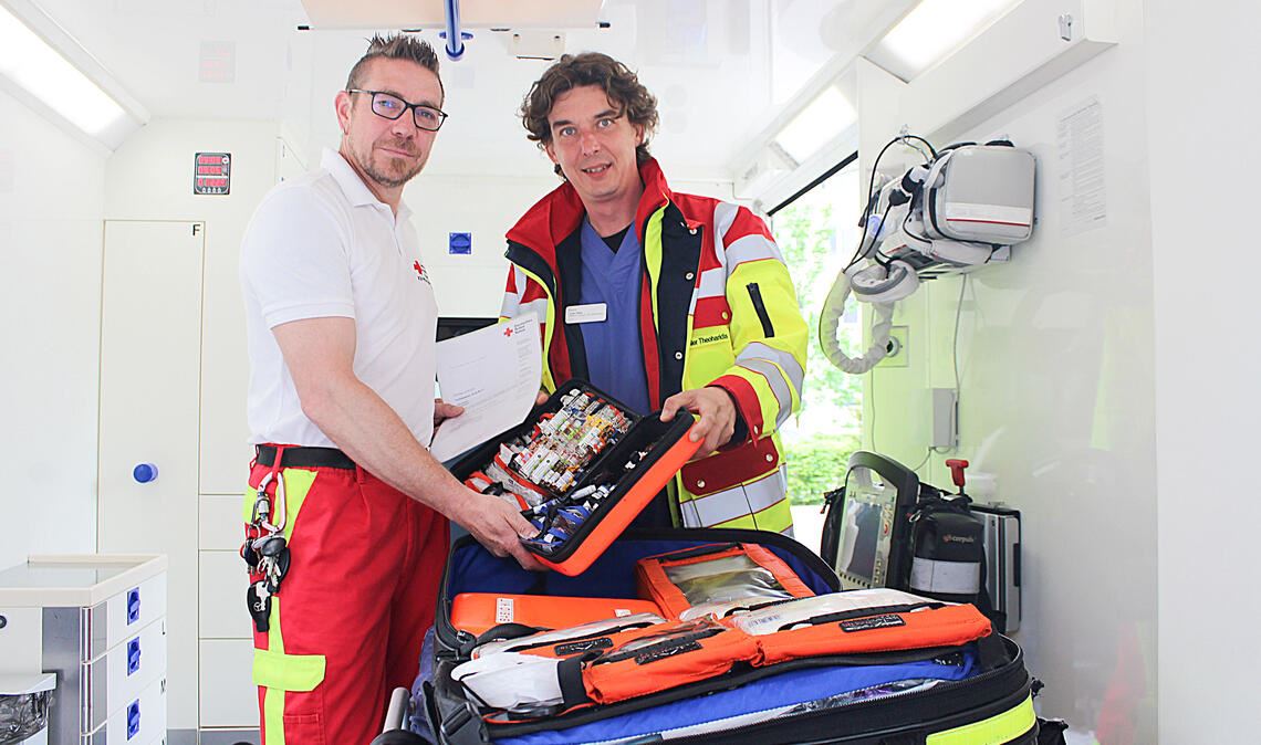 DRK-Notfallsanitäter Sven Thieme (li.) hat vom Mediziner Lutz Zöller-Theoharidis per Urkunde bestätigt bekommen, dass er seinen Patienten nun bereits vor dem Eintreffen eines Arztes oder einer Ärztin bestimmte Medikamente verabreichen darf. Foto: Kneis/DRK