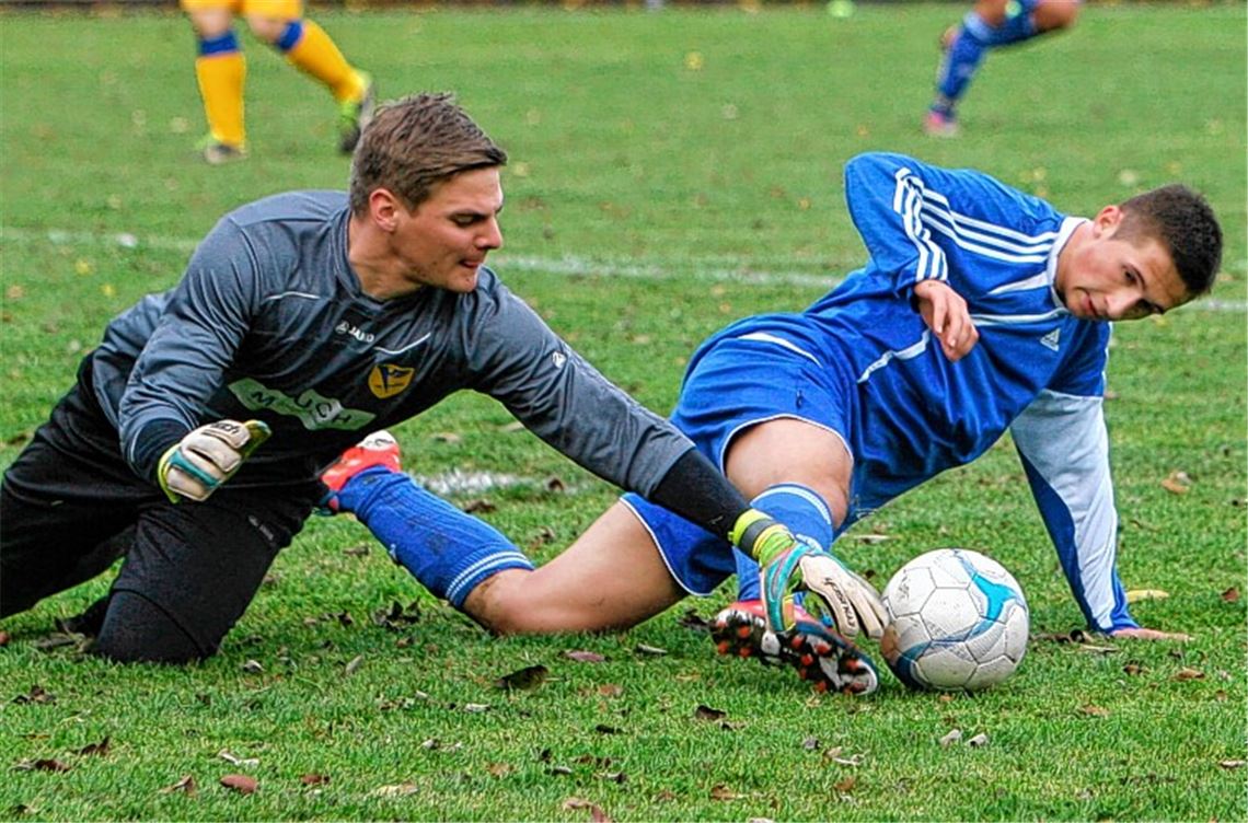 Daniel Kern (li.) streckt sich vergeblich, Renningens Eugen Schön spitzelt dem Lomersheimer Schlussmann den Ball unter dem Handschuh weg. Foto: Gorr