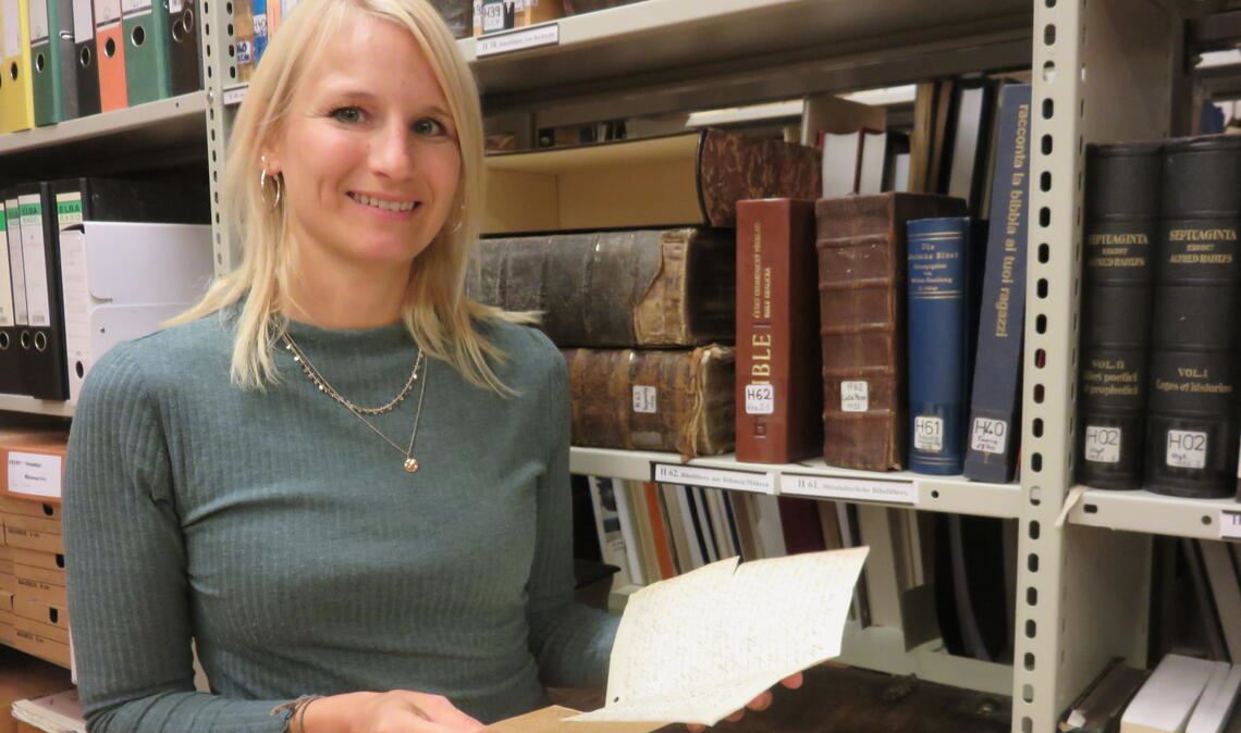 Daniela Falz hat von Dr. Albert de Lange das Amt des Wissenschaftlichen Vorstands in der Deutschen Waldenservereinigung übernommen. Schon vorher hat sie mit ihm zusammengearbeitet und kennt sich in der Bibliothek und im Archiv des Waldensermuseums aus. Für dieses Interview hat sie aus dem Archiv ein besonderes Dokument hervorgeholt. Es handelt sich um eine Transkription, die einst Pfarrer Märkt von der Rede anfertigte, die der Waldenser Daniel Gille 1899 auf Patouà vor dem württembergischen König hielt. Foto: Becker