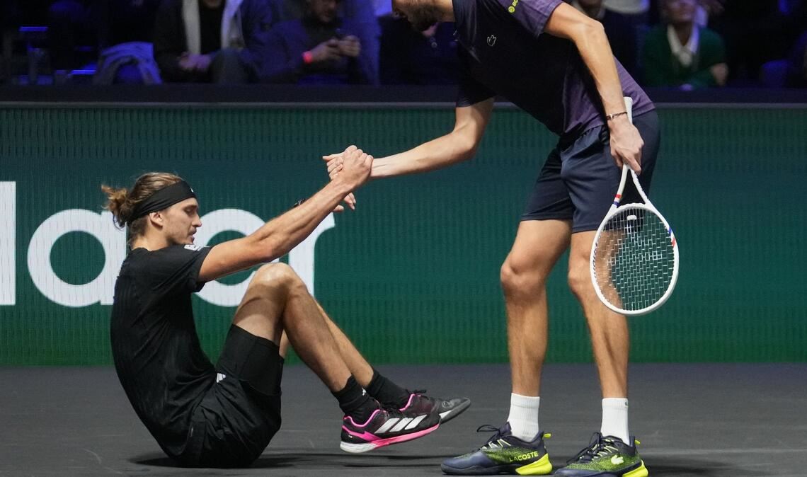 Daniil Medwedew hilft Alexander Zverev (l) nach einem Sturz auf.