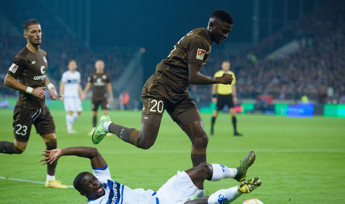 Darmstadts Braydon Manu (l) versucht St. Paulis Afeez Aremu vom Ball zu trennen.