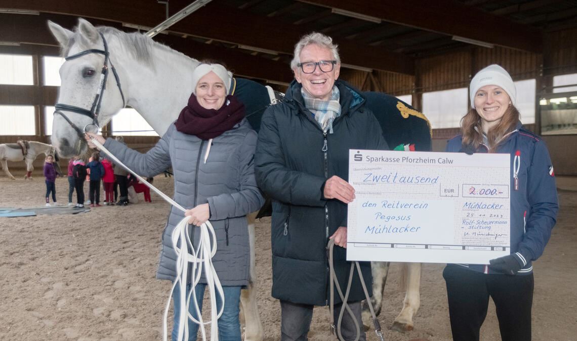 Das Bild zeigt Ulrich Münchinger bei der Spendenübergabe an Franziska Köppl (links) und Antonia Adelhelm.