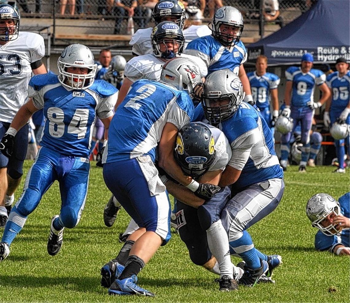 Das Gastspiel mit großem Rahmenprogramm im Holzhof-Stadion lohnt sich: Rund 700 Zuschauer wollen das Oberliga-Spitzenspiel sehen, in dem die Defense der Pforzheim Wilddogs (in Blau) den Biberach Beavers kein Durchkommen gestattet. Foto: Jürgen Keller