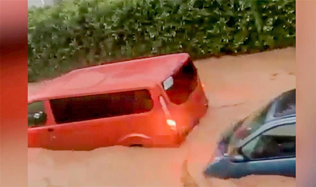 Das Hochwasser reißt Autos mit.