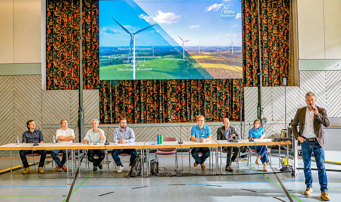 Das Podium bei der Windkraft-Informationsveranstaltung in der Iptinger Kreuzbachhalle (v.li.): Julian Schreder und Benjamin Boy von der Firma „Stromernte“, Georg Honold und Michael Schweizer vom Unternehmen Schweizer-Honold-Energiesysteme, Holger Techert, Abteilungsleiter Wind Stadtwerke Stuttgart, Dr. Christian Koch, Physiker der Physikalisch-Technischen Bundesanstalt bei Braunschweig, Dr. Nour Hane Merabet, Projektleiterin Windpark Iptingen der Stadtwerke Stuttgart, und Bürgermeister Matthias Enz. Foto: Bastian