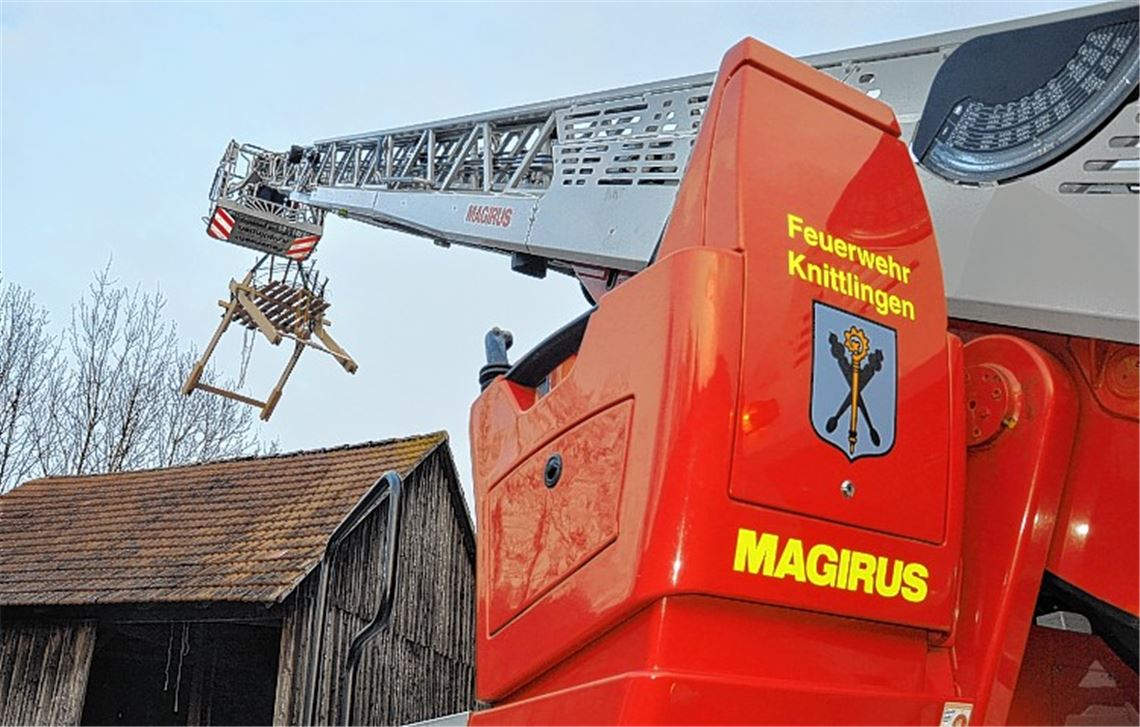 Das Storchennest wird mit Hilfe der Drehleiter auf das Dach der Scheune gehievt.