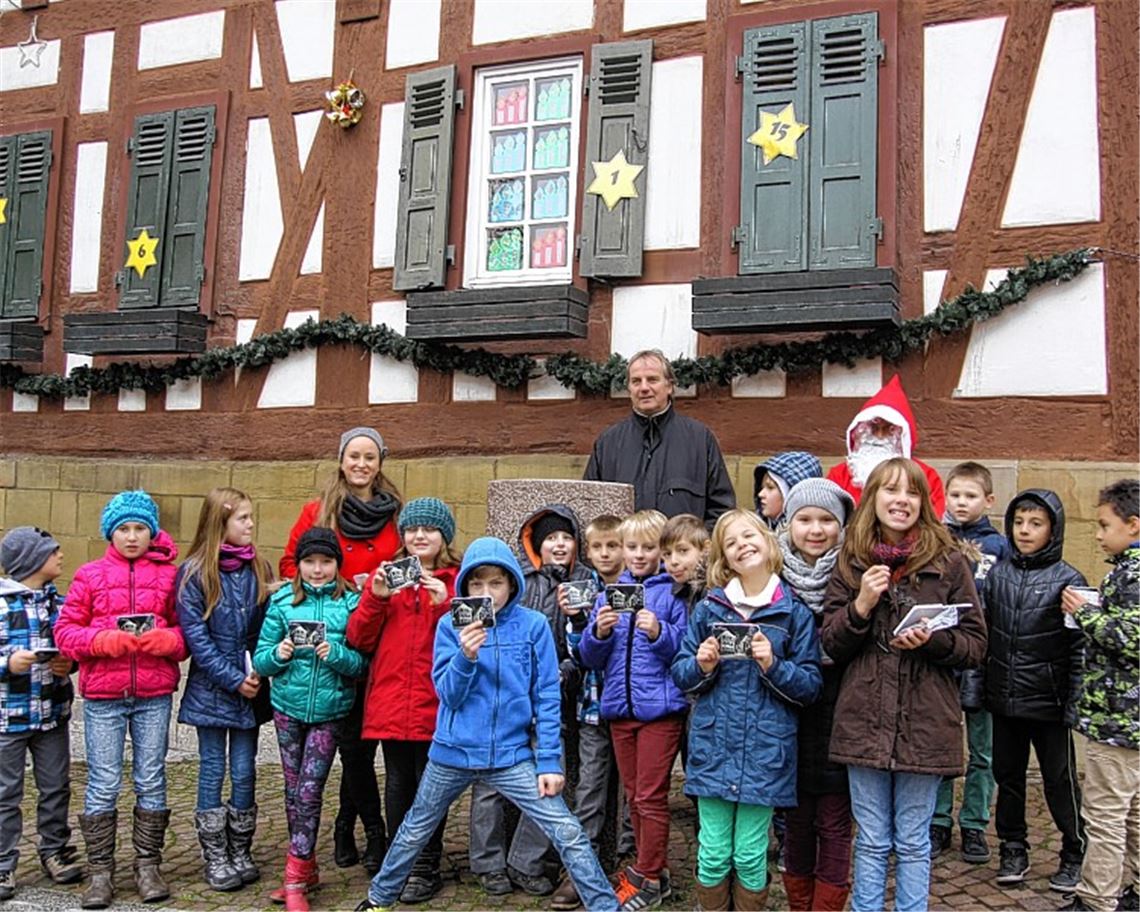 Das erste Fenster-Türchen ist geöffnet: Bürgermeister Heinz-Peter Hopp mit einigen der Schulkinder.