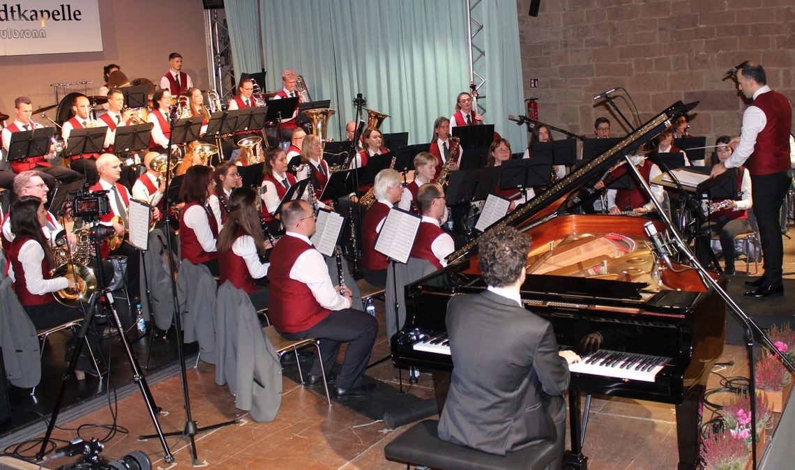 Das große Blasorchester der Stadtkapelle spielt gemeinsam mit Pianist Dennis Kozarov. Foto: Gießler