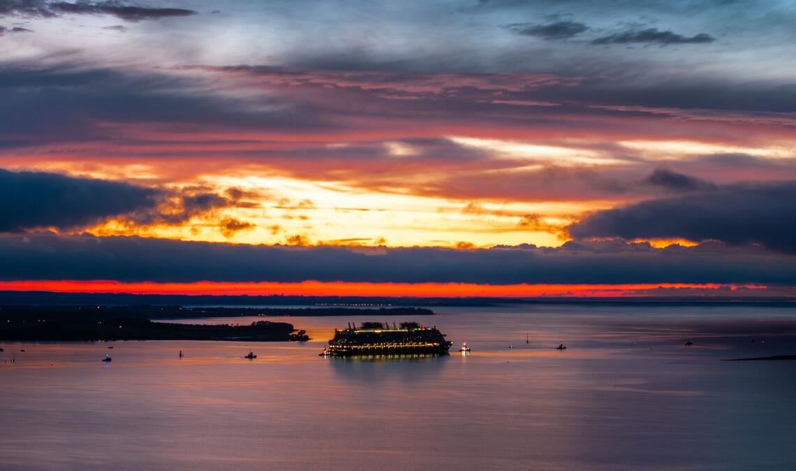 Bilder des Tages Das in der Wismarer Werft gebaute Kreuzfahrtschiff „Disney Adventure“ wird von mehreren Schleppern nach Sonnenuntergang durch die Wismarbucht in Richtung Ostsee gezogen.