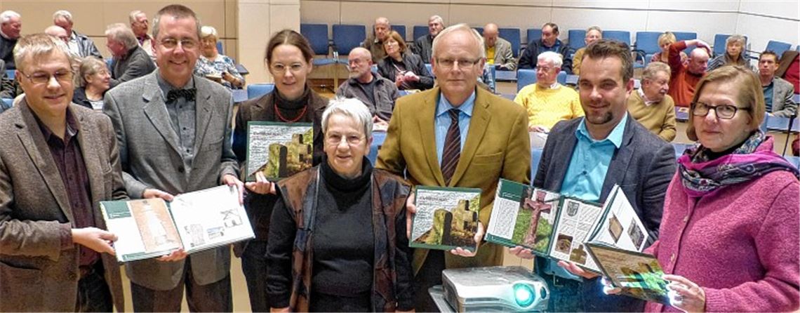 Das noch druckfrische Buch über die Kleindenkmale des Enzkreises präsentieren (v.li.): Kreisarchivar Konstantin Huber, Erster Landesbeamter Wolfgang Herz, Autorin Catharina Raible, Koordinatorin Barbara Hauser, Landrat Karl Röckinger, Harald Funke (Verlag) und Denkmalpflegerin Martina Blaschka vom Regierungspräsidium Stuttgart). Anwesend sind auch viele der ehrenamtlichen Co-Autoren.