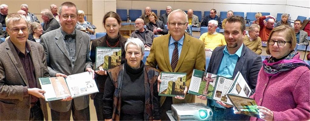 Das noch druckfrische Buch über die Kleindenkmale des Enzkreises präsentieren (v.li.): Kreisarchivar Konstantin Huber, Erster Landesbeamter Wolfgang Herz, Autorin Catharina Raible, Koordinatorin Barbara Hauser, Landrat Karl Röckinger, Harald Funke (Verlag) und Denkmalpflegerin Martina Blaschka vom Regierungspräsidium Stuttgart). Anwesend sind auch viele der ehrenamtlichen Co-Autoren.