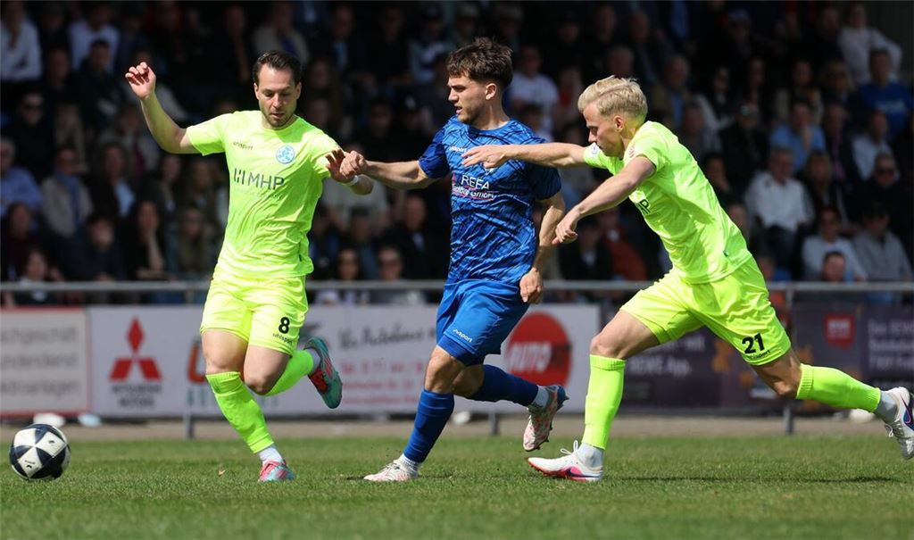 David Tomic (Kickers), Lukas Laupheimer (SGV Freiberg), Per Lockl (Kickers) im Kampf um den Ball (von links).