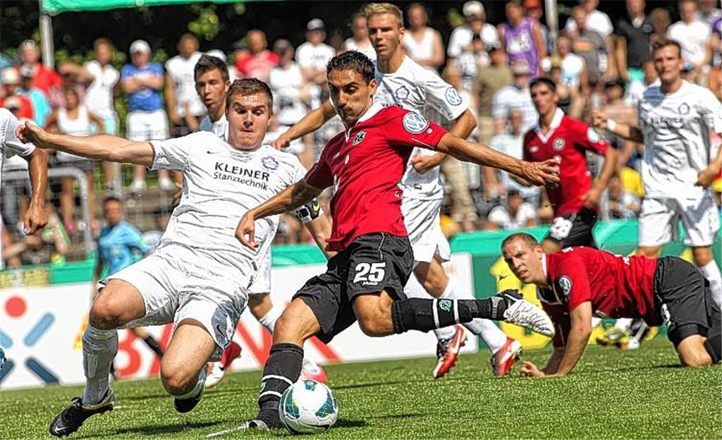 David gegen Goliath: Der Oberligist FC Nöttingen (weiße Trikots) setzt immer wieder Nadelstiche gegen Hannover 96. Trotzdem verliert die Mannschaft von Trainer Michael Wittwer 1:6 (0:2). Was neben dem Ergebnis viel mehr zählt, sind die 90 Minuten, in denen der kleine Verein bundesweit Beachtung erfährt.