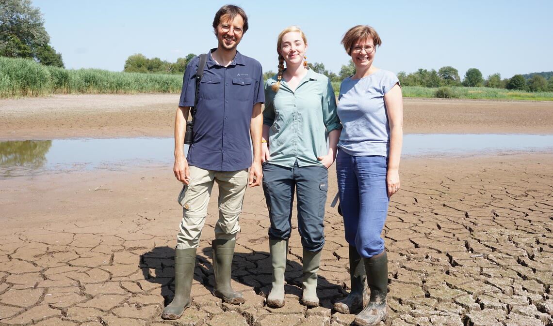 Dem Roßweiher in Maulbronn wird sehr bewusst das Wasser abgelassen. Warum das wichtig für das Gewässer ist, erläutern vor Ort Daniel Raddatz, Referatsleiter beim Regierungspräsidium Karlsruhe, Charlotte Backes vom Ökomobil und Andrea Wiedemann (re.), zuständig für den Naturschutz und die Landschaftspflege im Enzkreis. Foto: Bastian