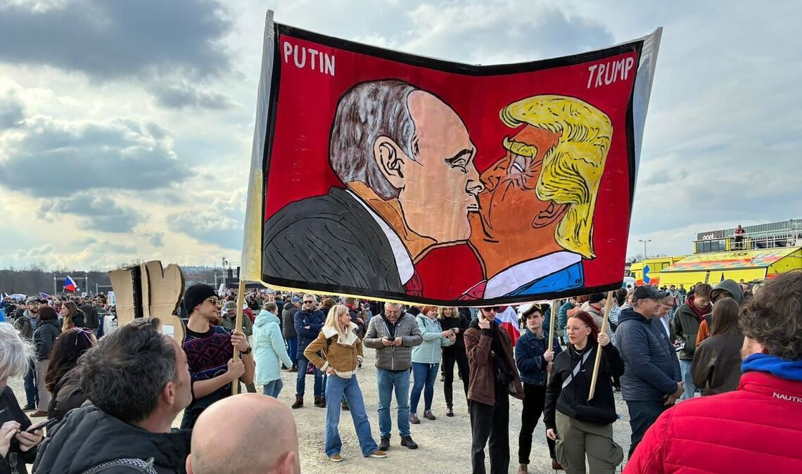 Demonstranten halten bei einer Kundgebung des Bündnisses "Eine Million Augenblicke für Demokratie" ein Banner, auf dem sich stilisiert US-Präsident Trump und Russlands Präsident Putin küssen.