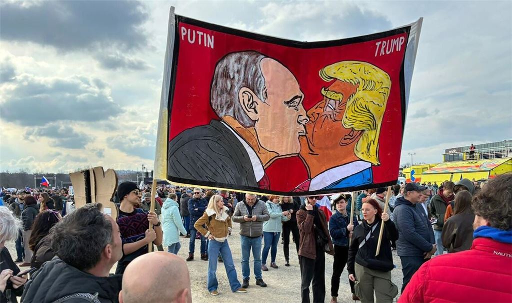 Demonstranten halten bei einer Kundgebung des Bündnisses "Eine Million Augenblicke für Demokratie" ein Banner, auf dem sich stilisiert US-Präsident Trump und Russlands Präsident Putin küssen.