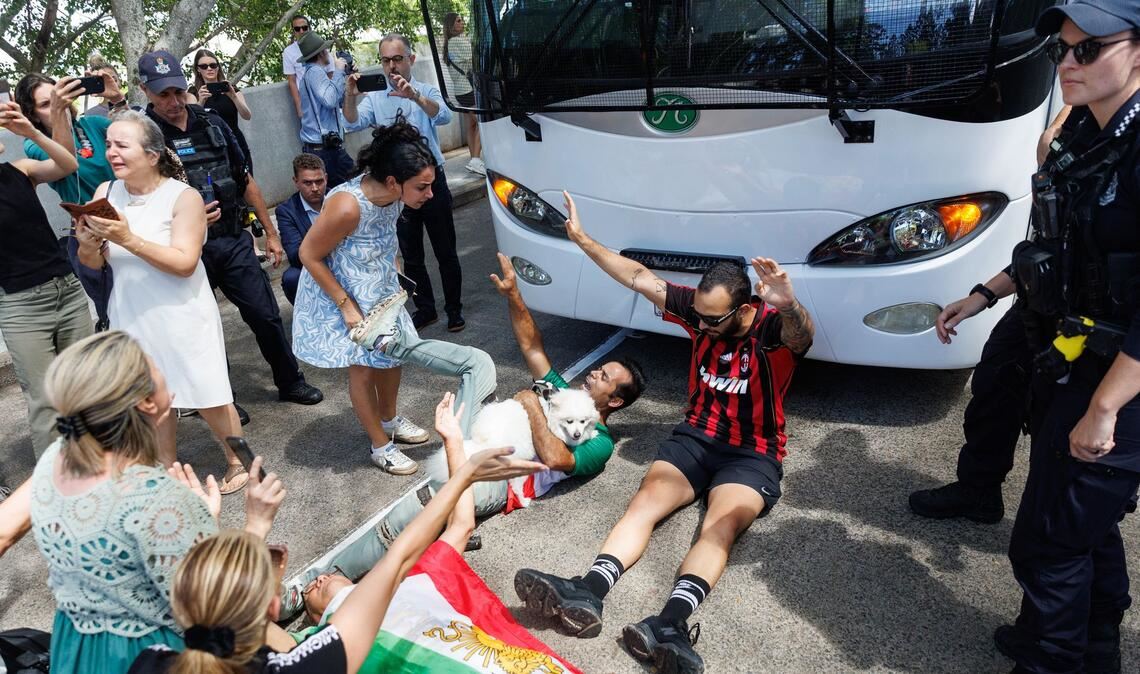 Demonstranten protestierten, während der Bus mit iranischen Spielerinnen und Mitarbeitern abfuhr.