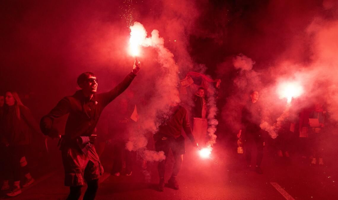 Demonstranten zünden Fackeln bei einer Kundgebung zum ersten Jahrestag der Bahnhofskatastrophe in Novi Sad an.