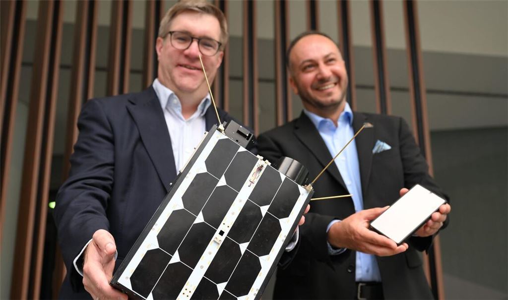 Demonstrativ gute Laune von O2-Manager Jörg Kablitz und OQ-Chef Omar Qaise, die bei der Vorstellung ihres Vorhabens ein Modell eines Satelliten dabeihatten.