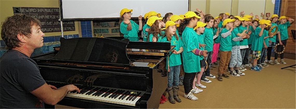 Den „Lemon Tree“-Erfinder als Chorleiter: Peter Freudenthaler gefällt sich in dieser Rolle, und die Kinder singen den Hit voller Inbrunst. Foto: Kollros