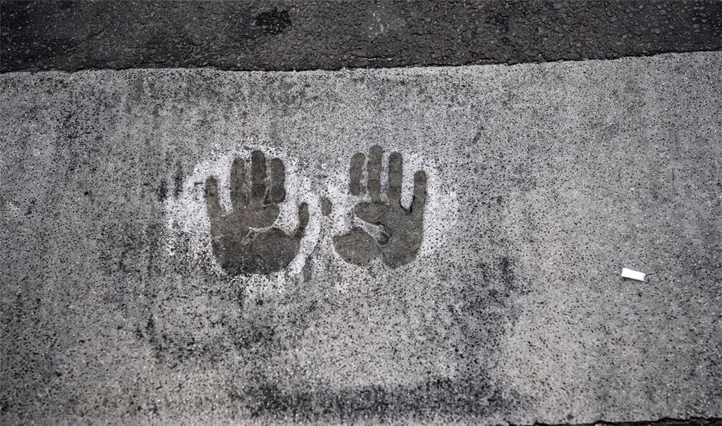 Der Abdruck von zwei Händen bei einer Straßenblockade der Letzten Generation auf dem Mühlendamm in Berlin.