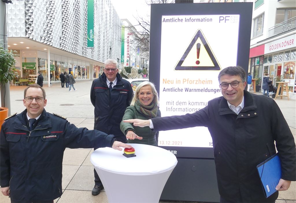 Der „Alarmknopf“ vor der neuen digitalen Stadtinformationstafel hat nur symbolischen Charakter (v. li.): Feuerwehrkommandant Sebastian Fischer, Katastrophenschützer Frank Winterfeldt, Evelyn Lerche von der Firma Ströer und WSP-Direktor Oliver Reitz. Foto: Roth