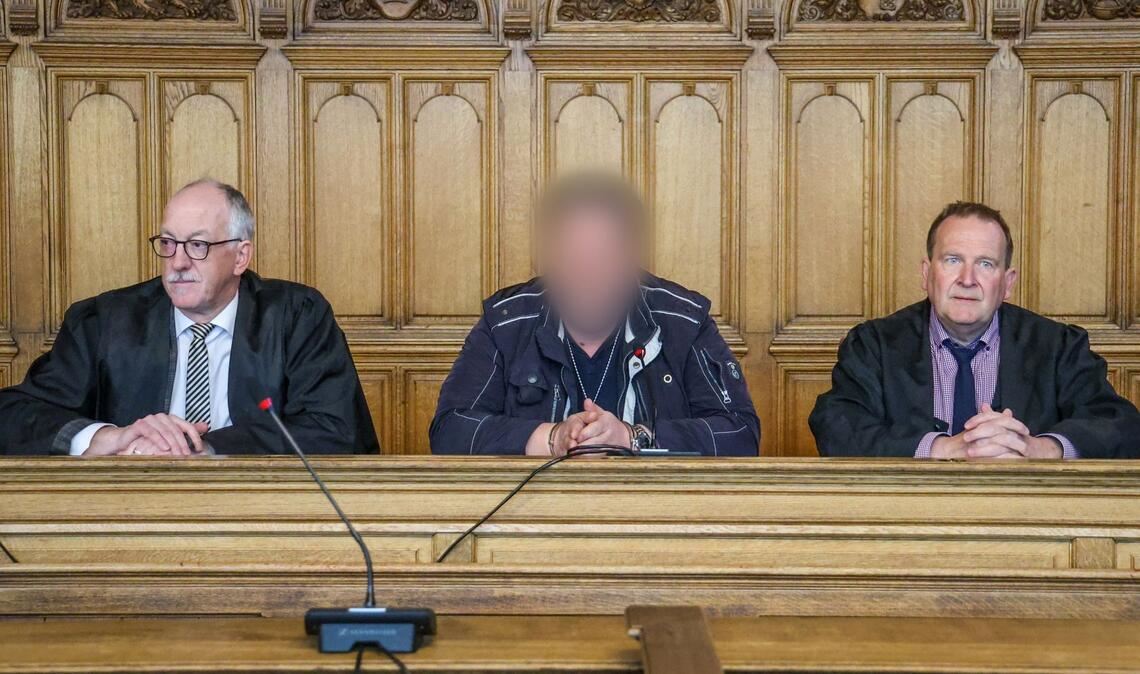 Der Angeklagte (M) sitzt vor der Urteilsverkündung im Prozess wegen Mordes im Landgericht Bremen zwischen seinen Verteidigern.