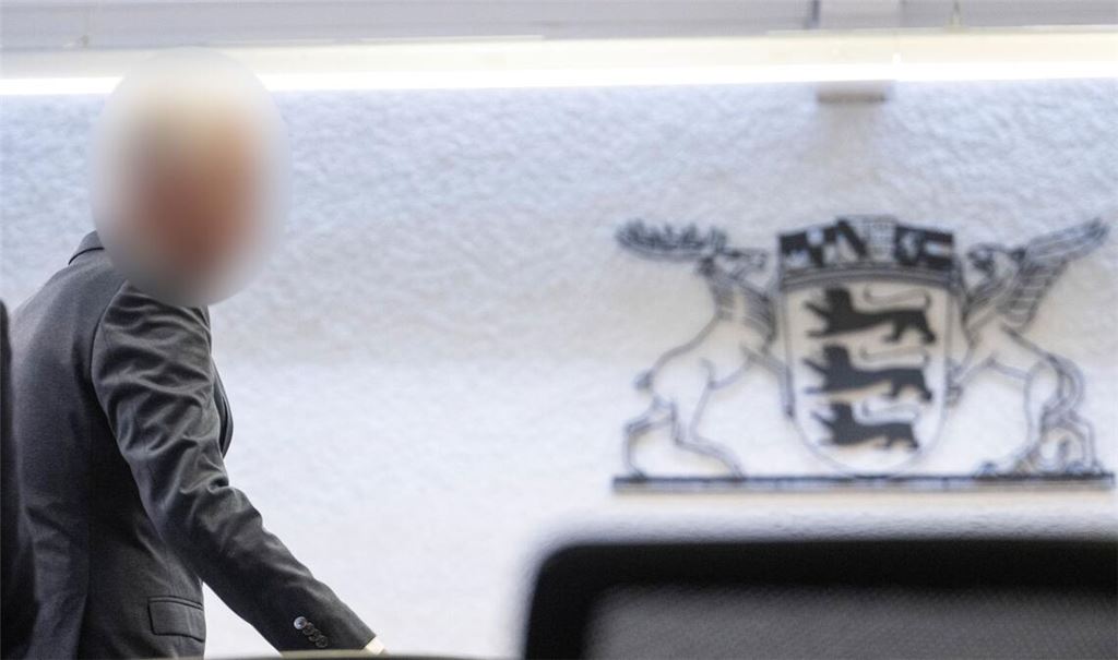 Der Angeklagte in einem Prozess wegen Bestechlichkeit steht in einem Saal des Landgerichts Stuttgart.