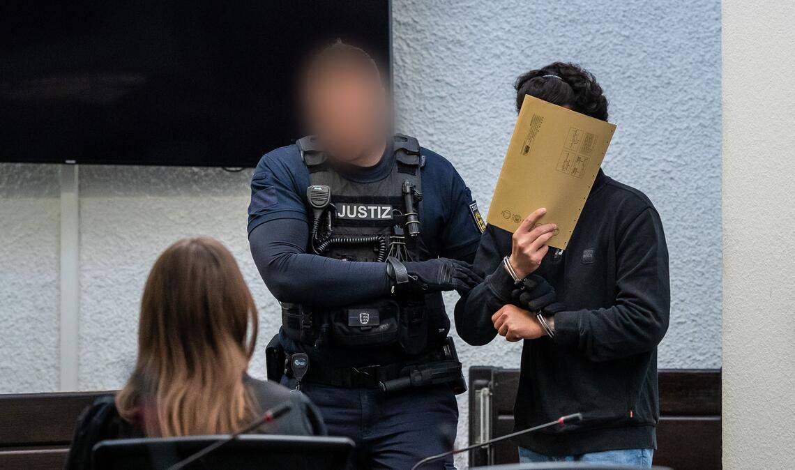 Der Angeklagte (rechts) wird in der Gerichtssaal geführt.