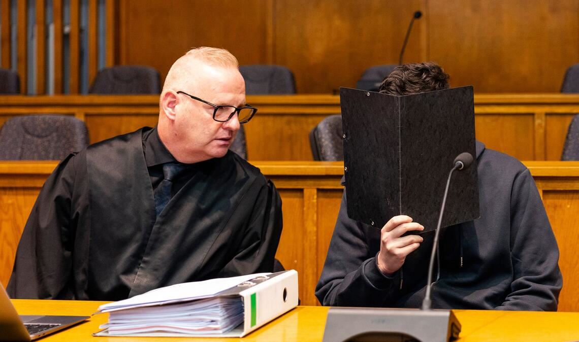 Der Angeklagte sitzt neben seinem Verteidiger im Gerichtssaal.